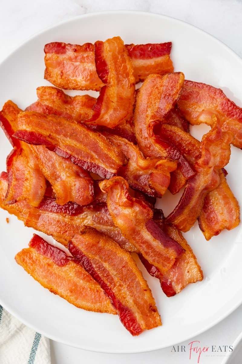 a round white plate filled with crispy air fryer bacon