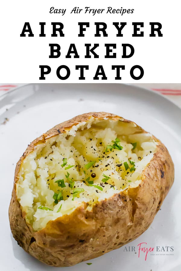 a baked potato topped with green herbs and black pepper on a round white plate