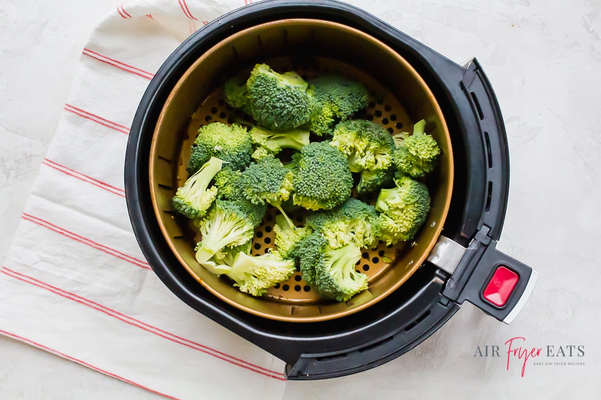 fresh broccoli florets in the basket of an air fryer