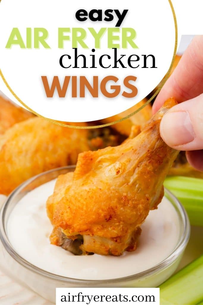a hand dipping a chicken wing drumstick into ranch dressing. Text overlay at the top says easy air fryer chicken wings