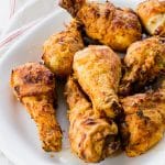 cooked browned fried chicken pieces on a white platter