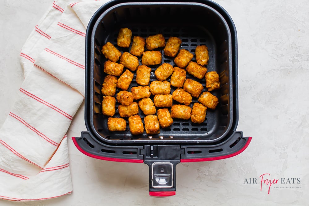 a square air fryer basket filled with tater tots