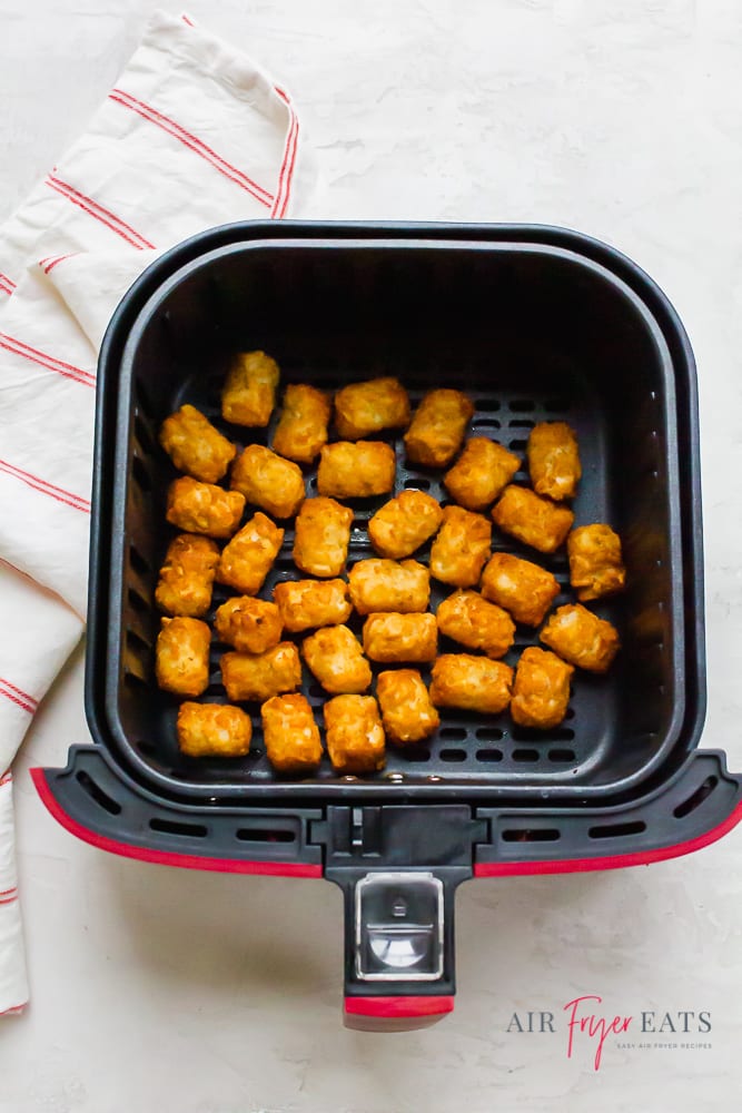 cooked tater tots in an air fryer basket