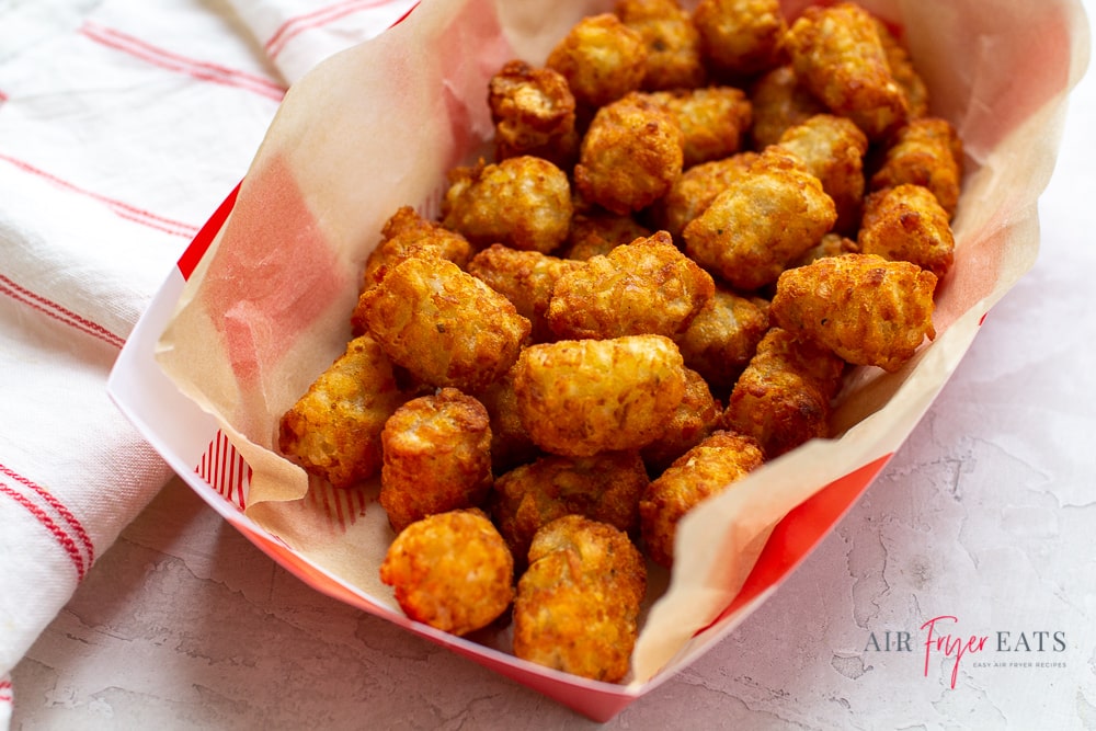 a paper basket filled with browned tater tots