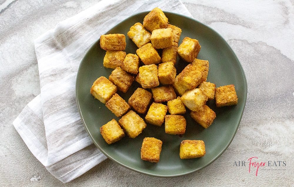cubes of browned breaded tofu on a round gray plate