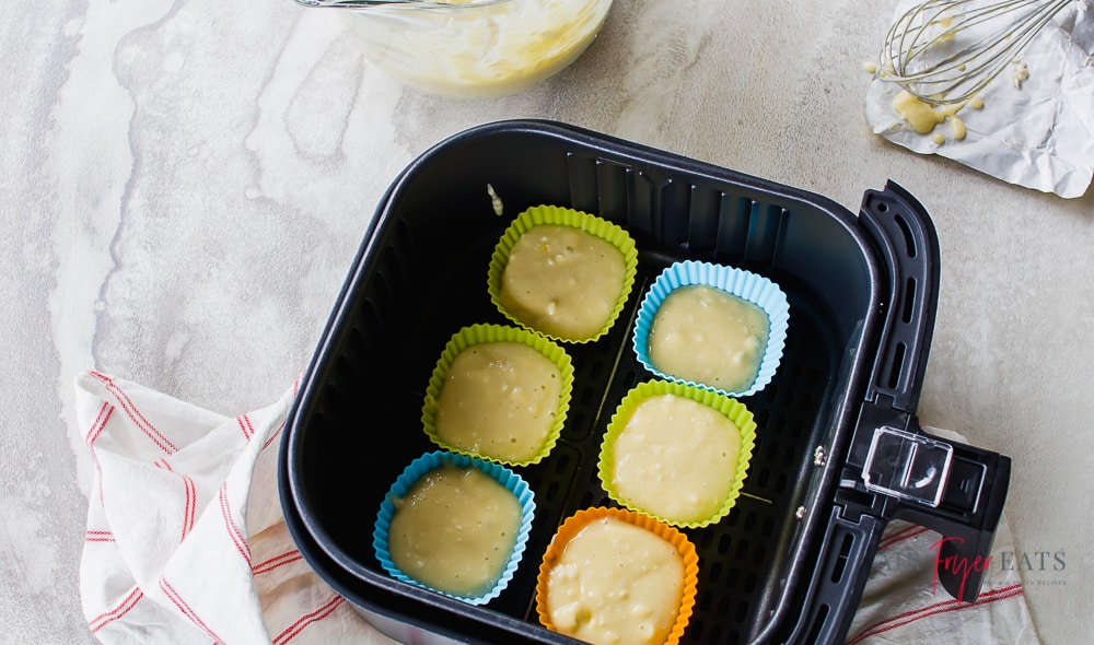 Cupcake batter (uncooked) in molds in air fryer basiet