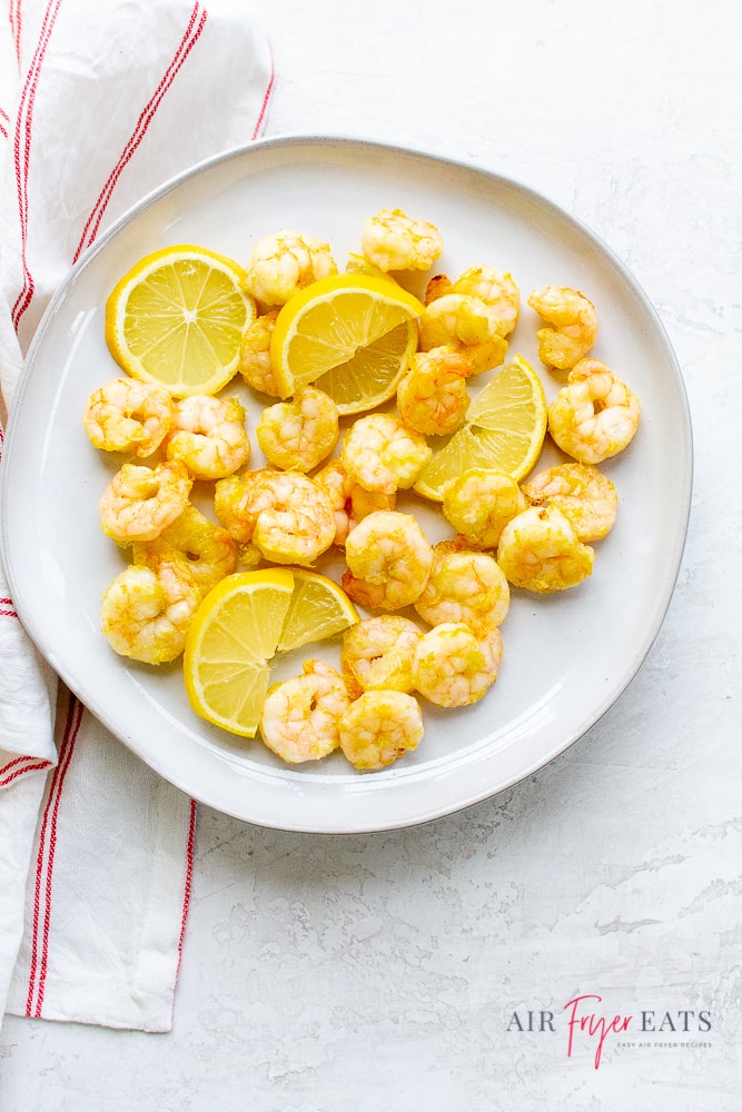 cooked shrimp and lemon slices on a round plate