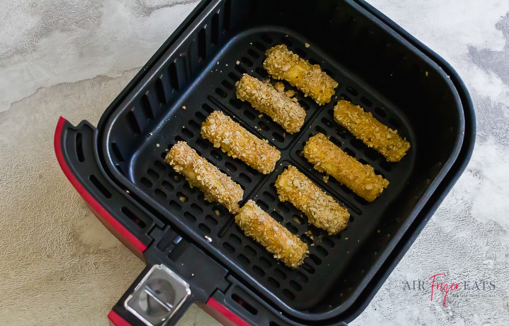 mozzarella sticks in an air fryer basket