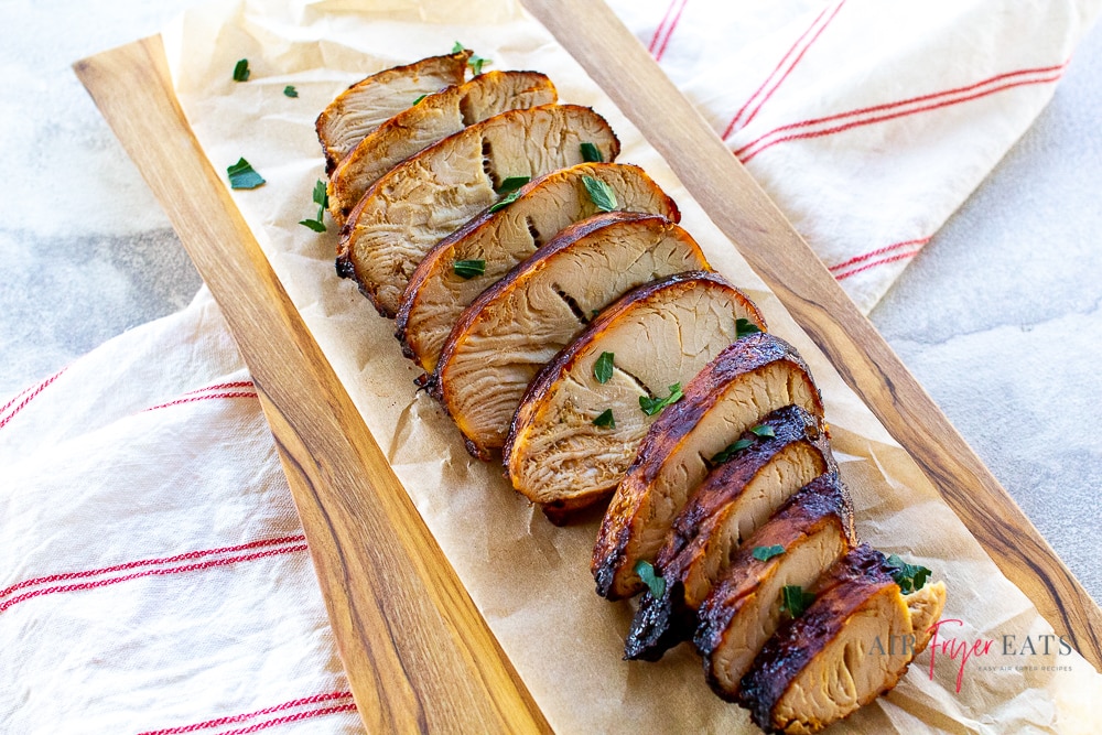 sliced turkey and parsley on parchment paper across and red and white striped towel