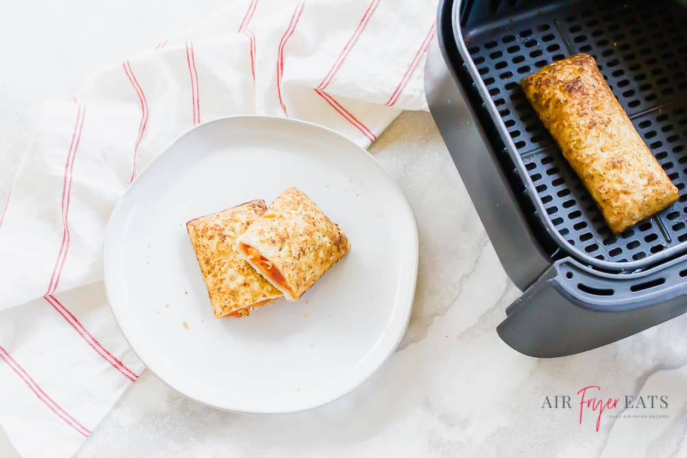 Horizontal picture showing a hotpocket cut in half stacked on a white plate on the left. Then on the right is a hot pocket in a black air fryer basket. 