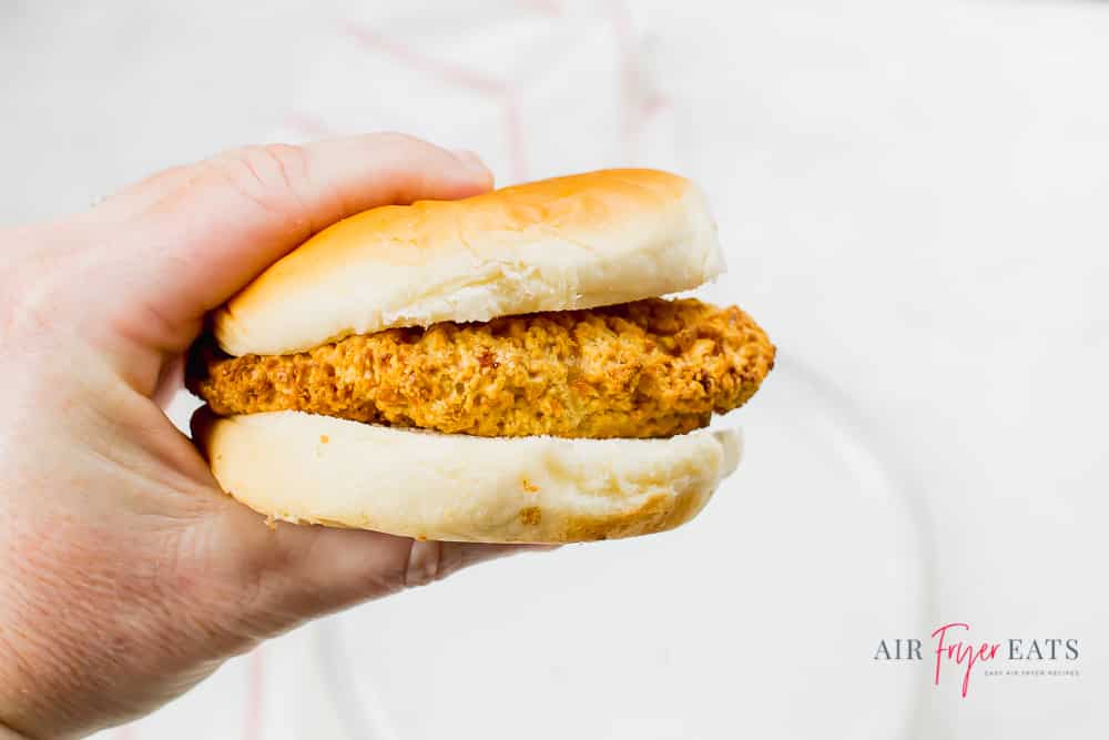 Tyson air fried chicken in a bun being held by a hand.