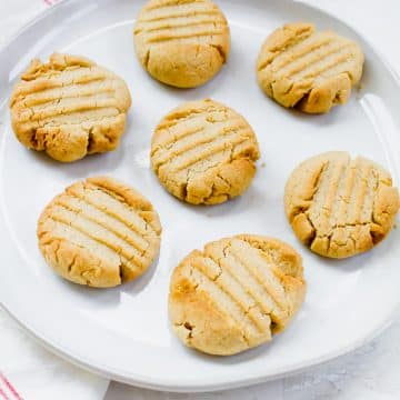 Seven peanut butter cookies on a white plate