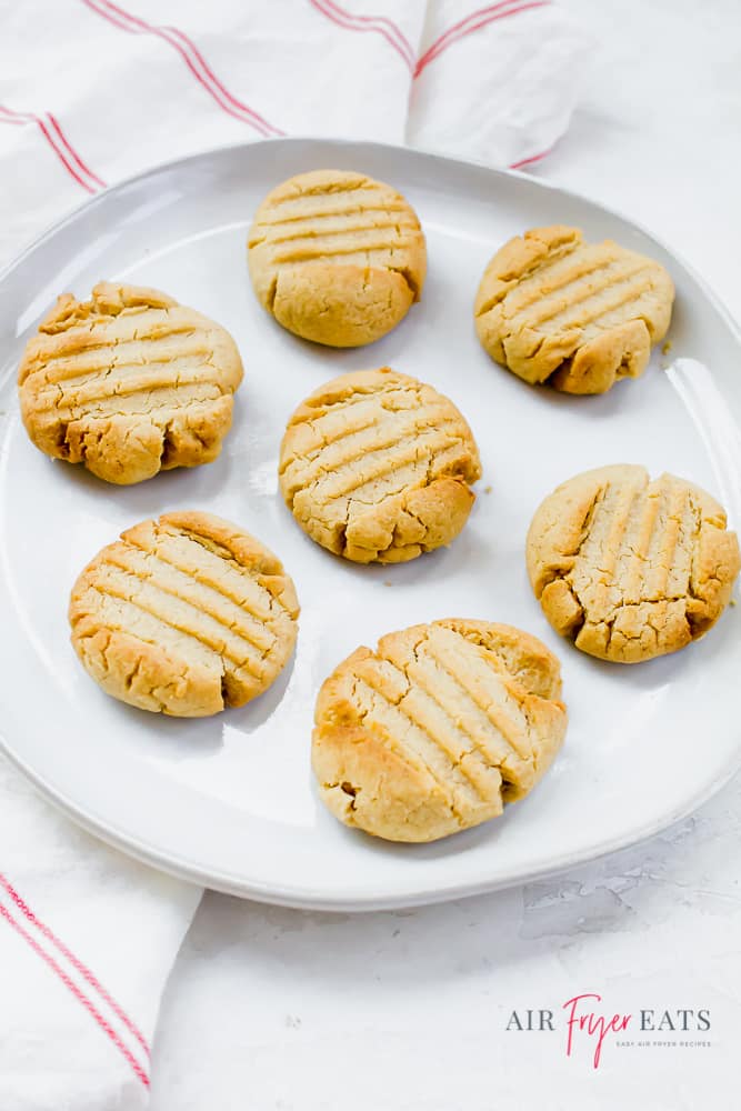 Seven peanut butter cookies on a white plate