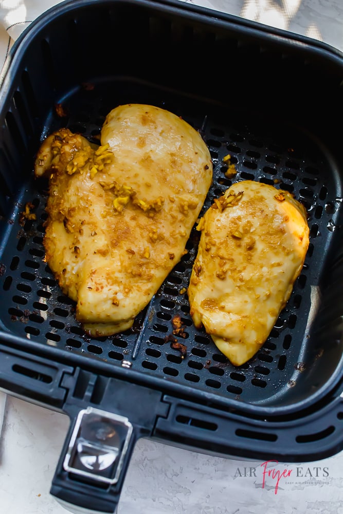 Overhead shot of sticky ginger chicken in an air fryer basket