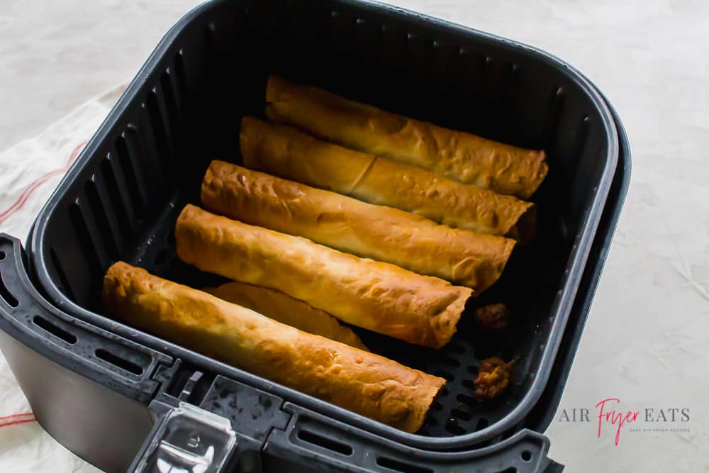 Homemade taquitos in an air fryer basket