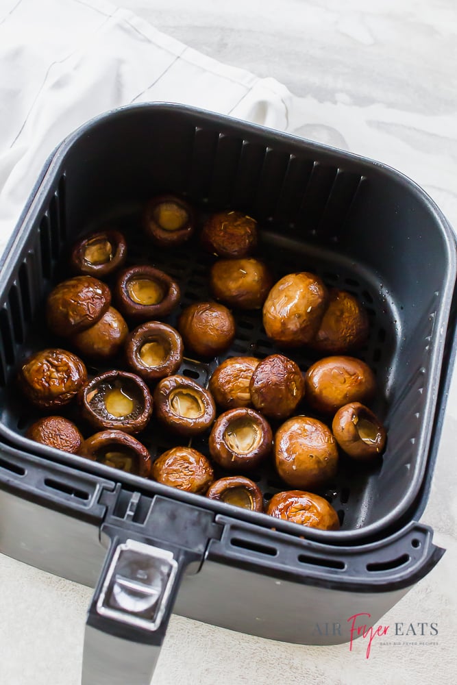 cooked mushroom caps in air fryer basket.