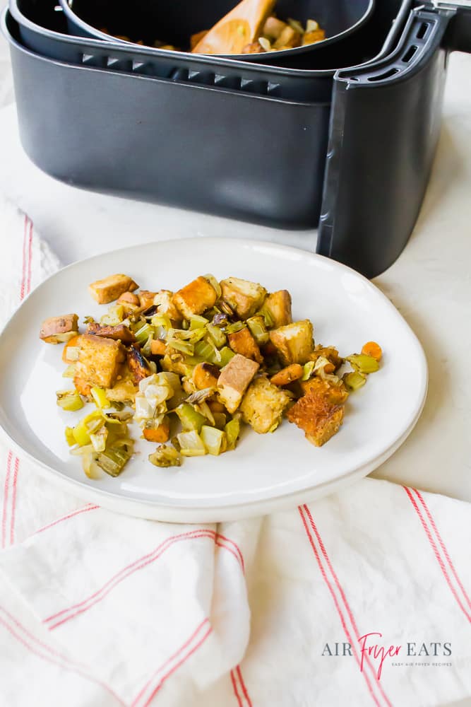 Air Fryer Stuffing on a white plate and also in a black air fryer basket