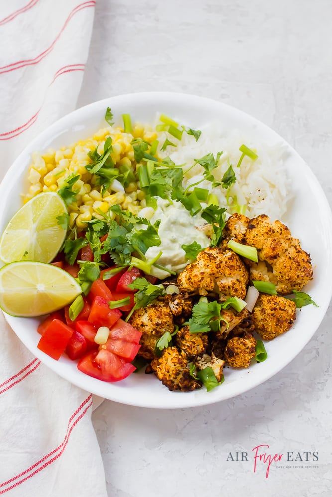 Vegetarian taco bowls with cauliflower, tomatoes, corn, rice, and cilantro