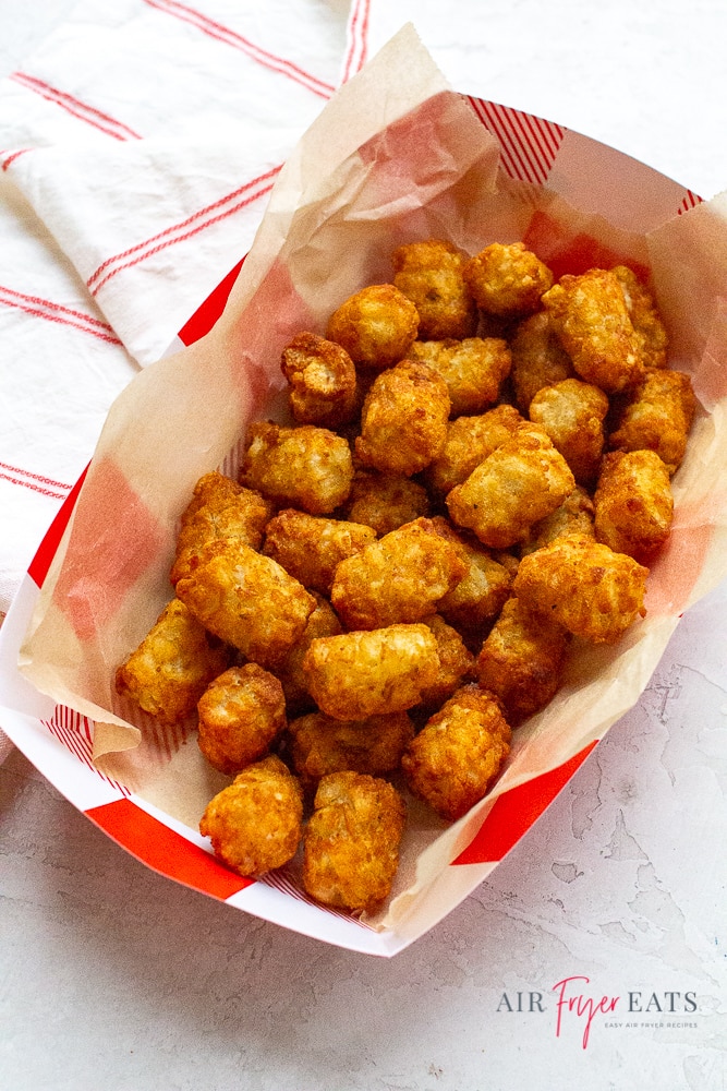 cooked air fryer tator tots in a white and red basket