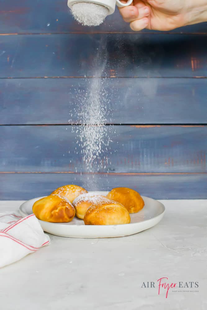 fried Oreos on a white plate dusted with powdered sugar