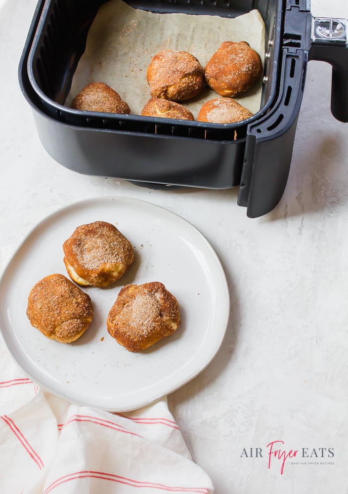 Gingerbread bites on a round white plate next to an air fryer basket