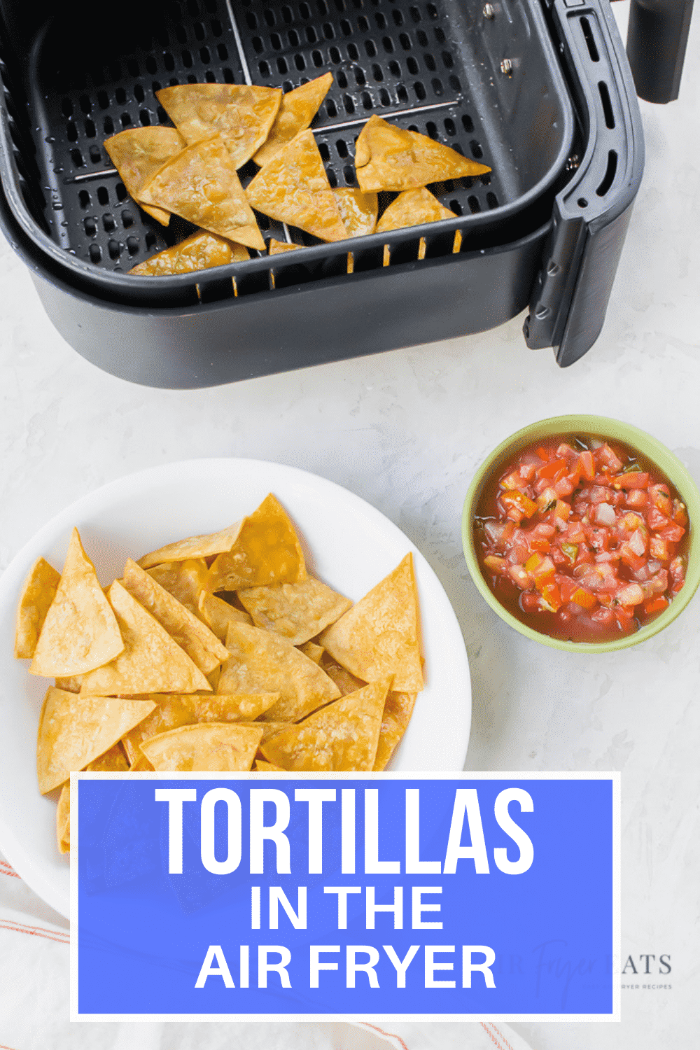 vertical picture. tortilla chips on a white plate at the bottom. red salsa in a green bowl and chips in an air fryer basket.