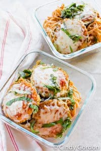 glass dishes filled with spaghetti and eggplant parmesan.