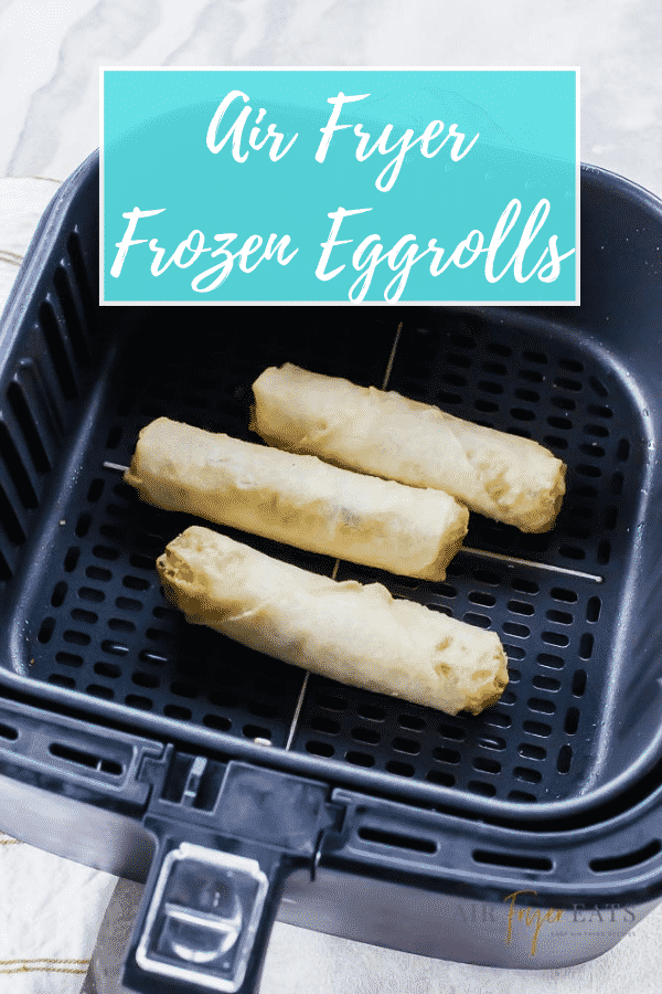 three egg rolls in black air fryer basket with text over lay saying air fryer frozen eggrolls