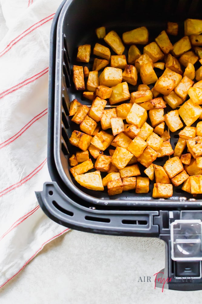 roasted cubed potatoes in an air fryer basket. 