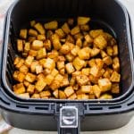 Top down view of cooked breakfast potatoes in the air fryer.