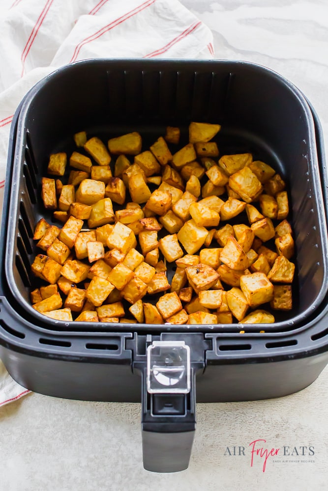 Top down view of cooked breakfast potatoes in the air fryer.