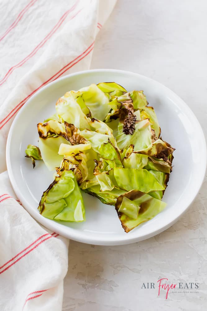 a white plate full of crispy green cabbage