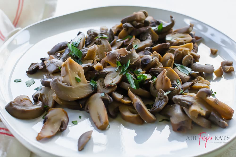 closeup view of mushrooms on a plate topped with herbs