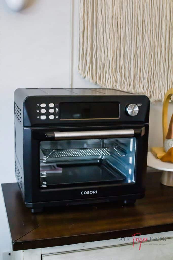 black air fryer oven sitting on wooden buffet