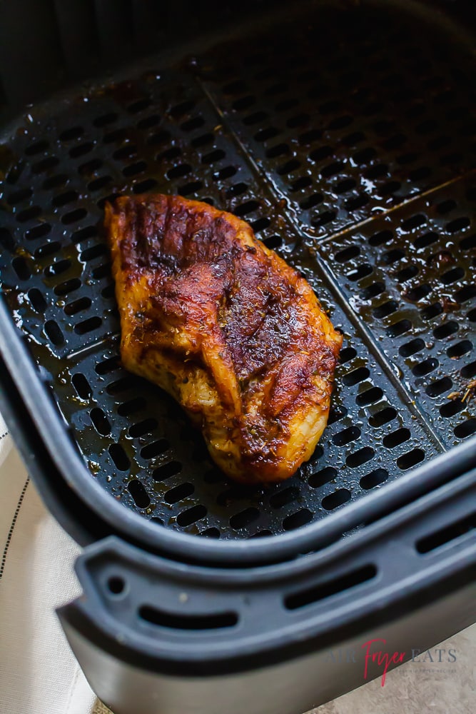 closeup view of a seasoned chicken breast in an air fryer
