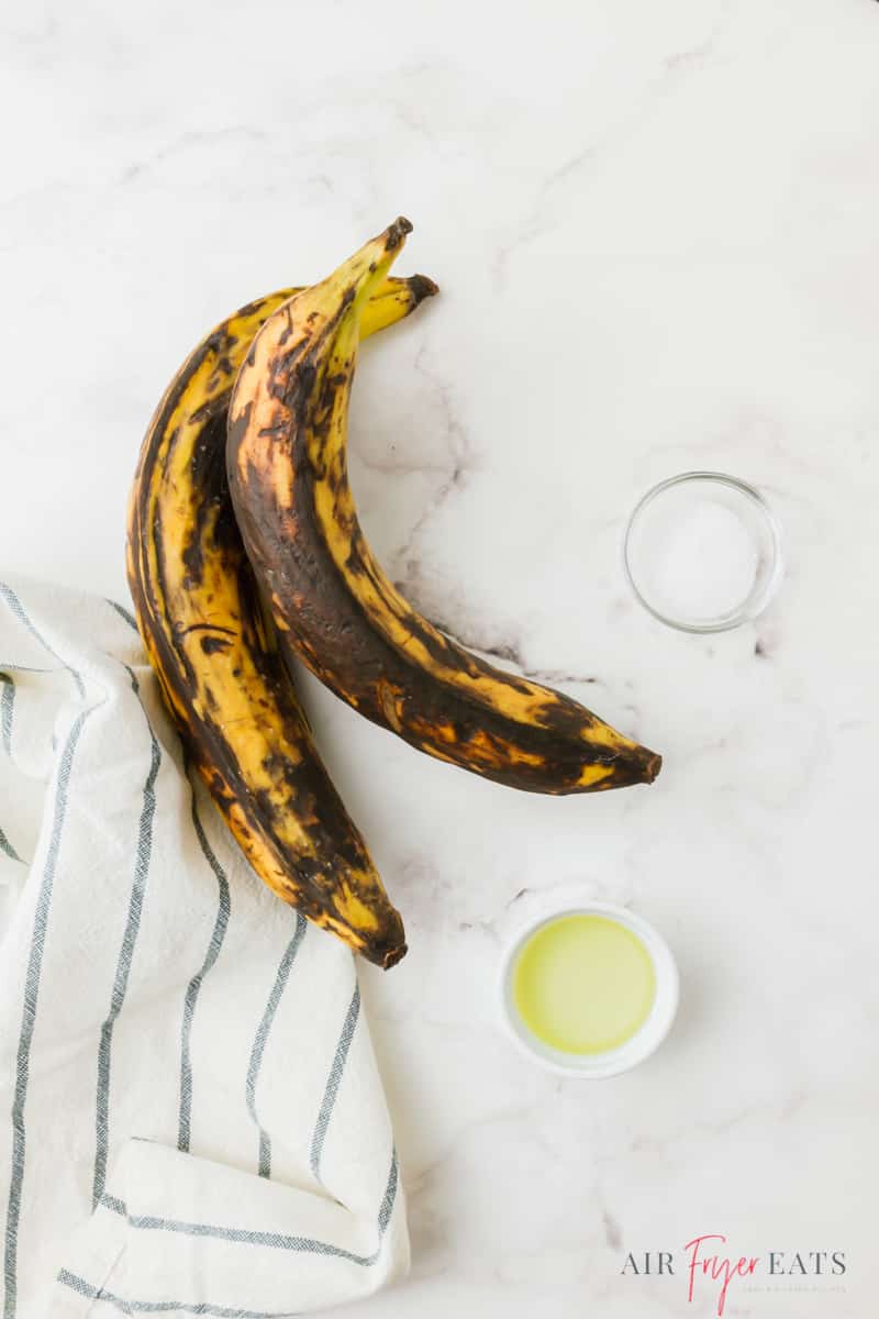 Ingredients needed for air fryer plantains on a marble countertop.