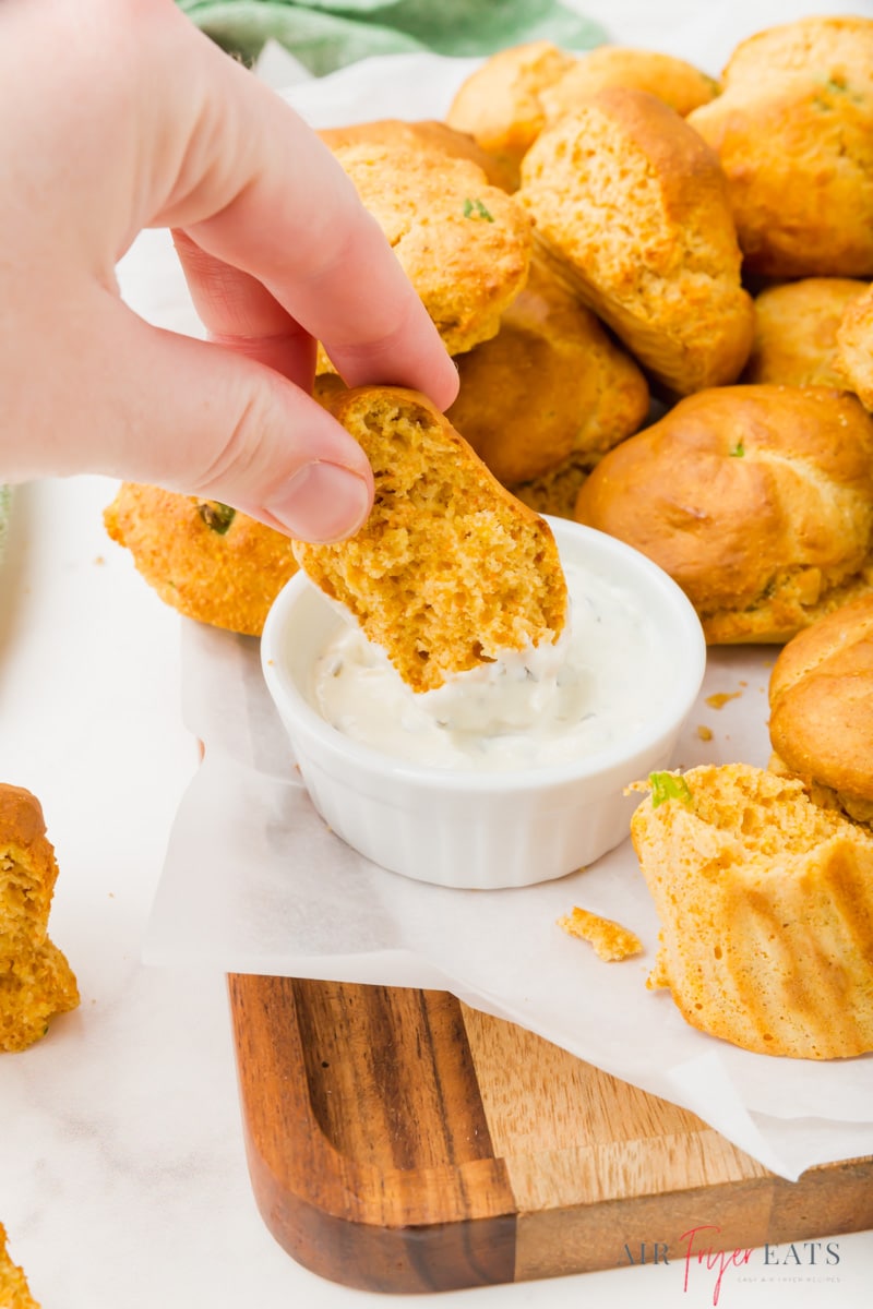 air fryer hushpuppy dipping into a creamy sauce