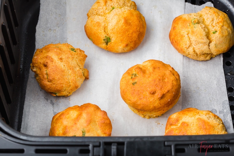 air fryer hush puppies in an air fryer basket lined with parchment paper