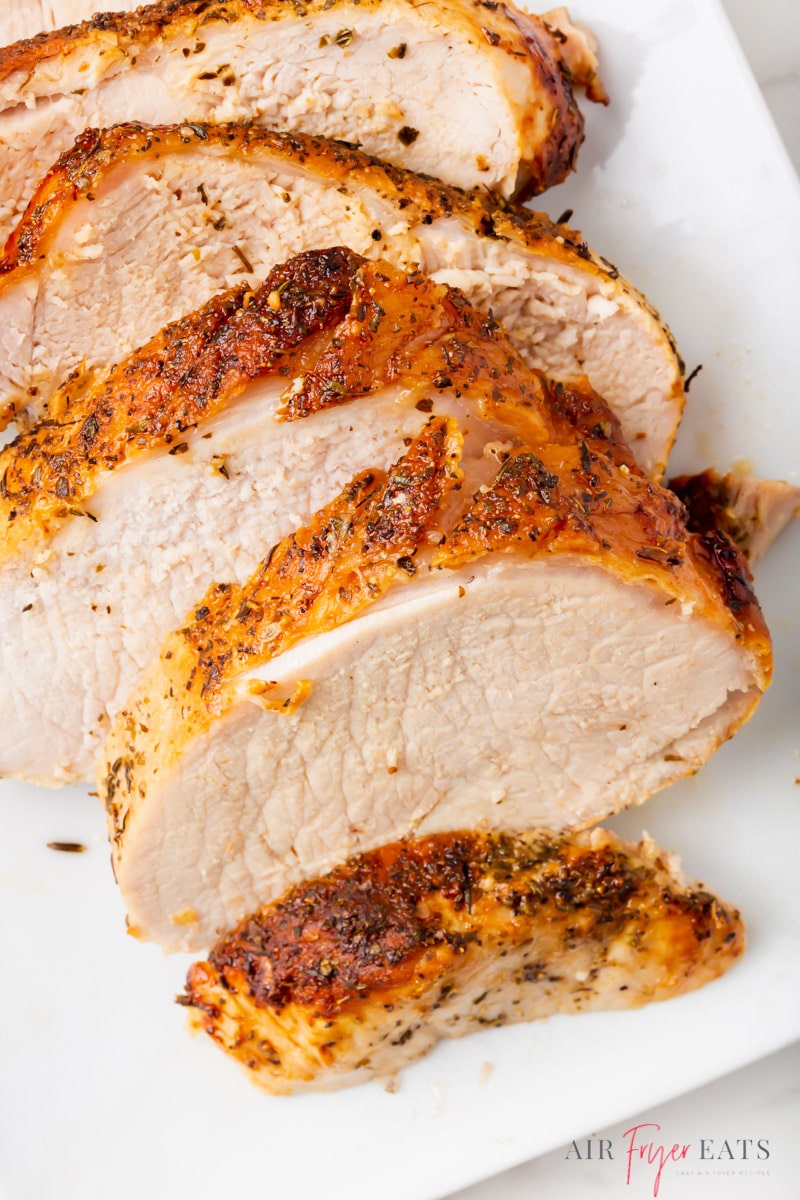 a sliced pork roast on a white plate. 