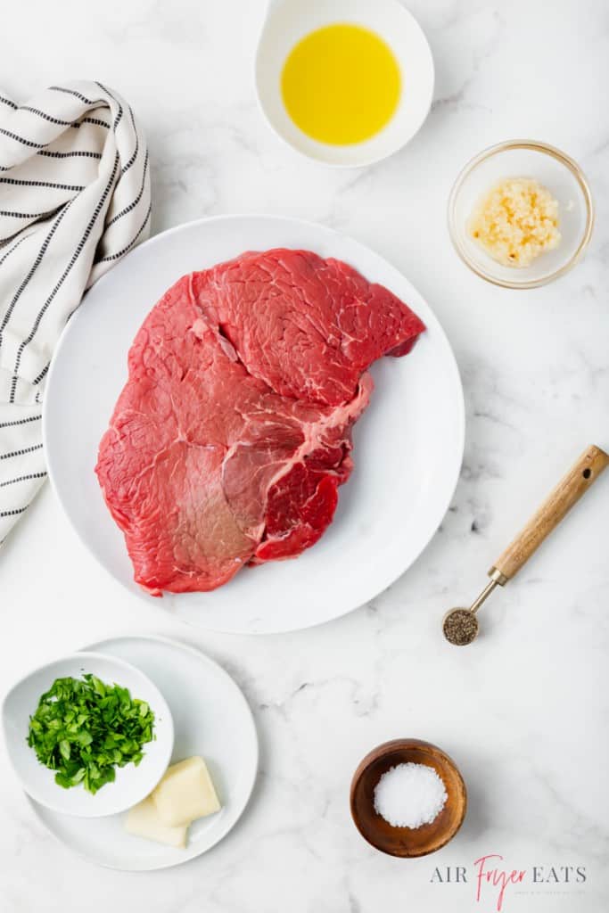 Ingredients for air fryer steak bites on a marble counter.