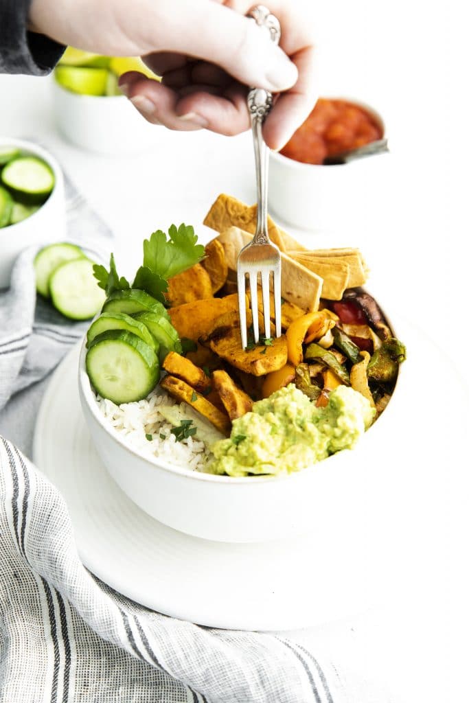 a vegetarian burrito bowl being eaten with a fork