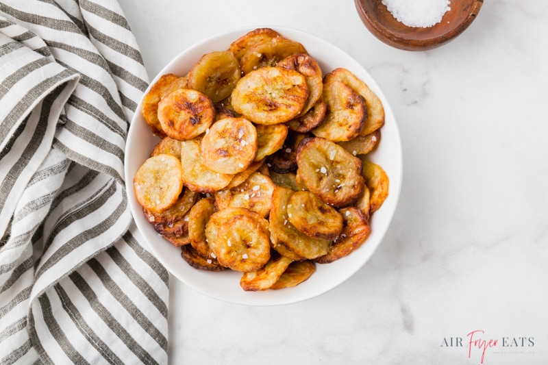 a bowl of banana crisps on a marble counter