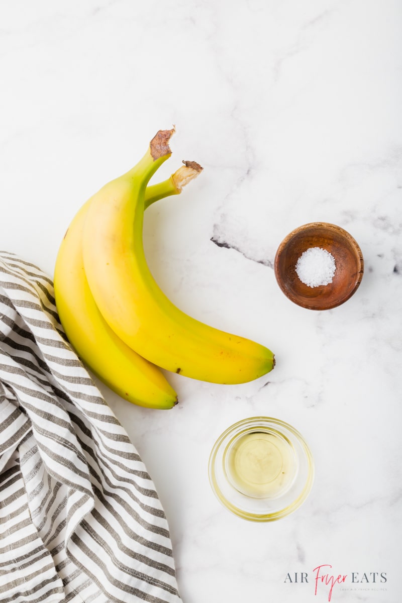 ingredients for air fryer banana chips on a marble counter.