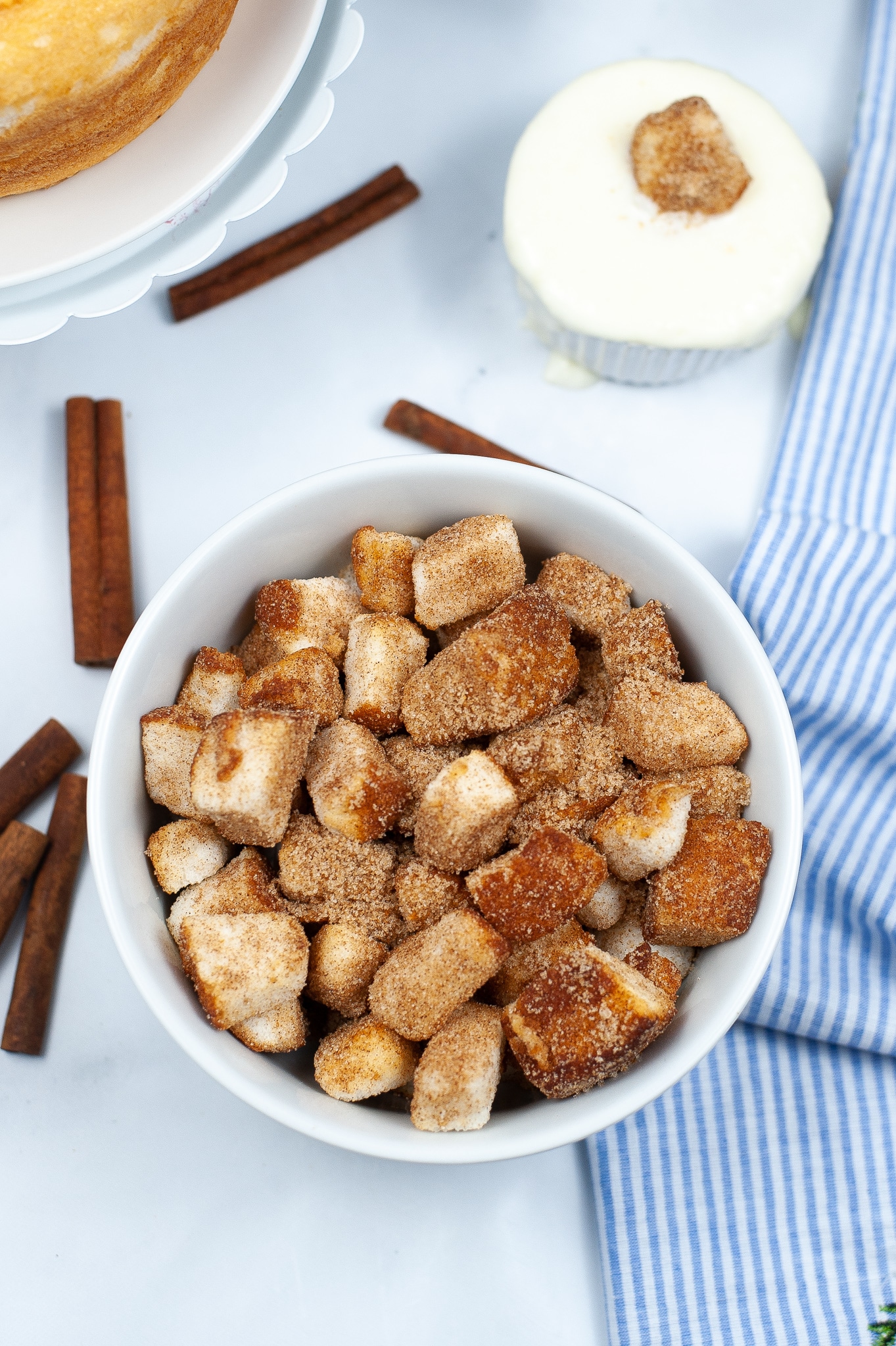 a bowl of air fryer churro bites in front of a bowl of vanilla icing dip