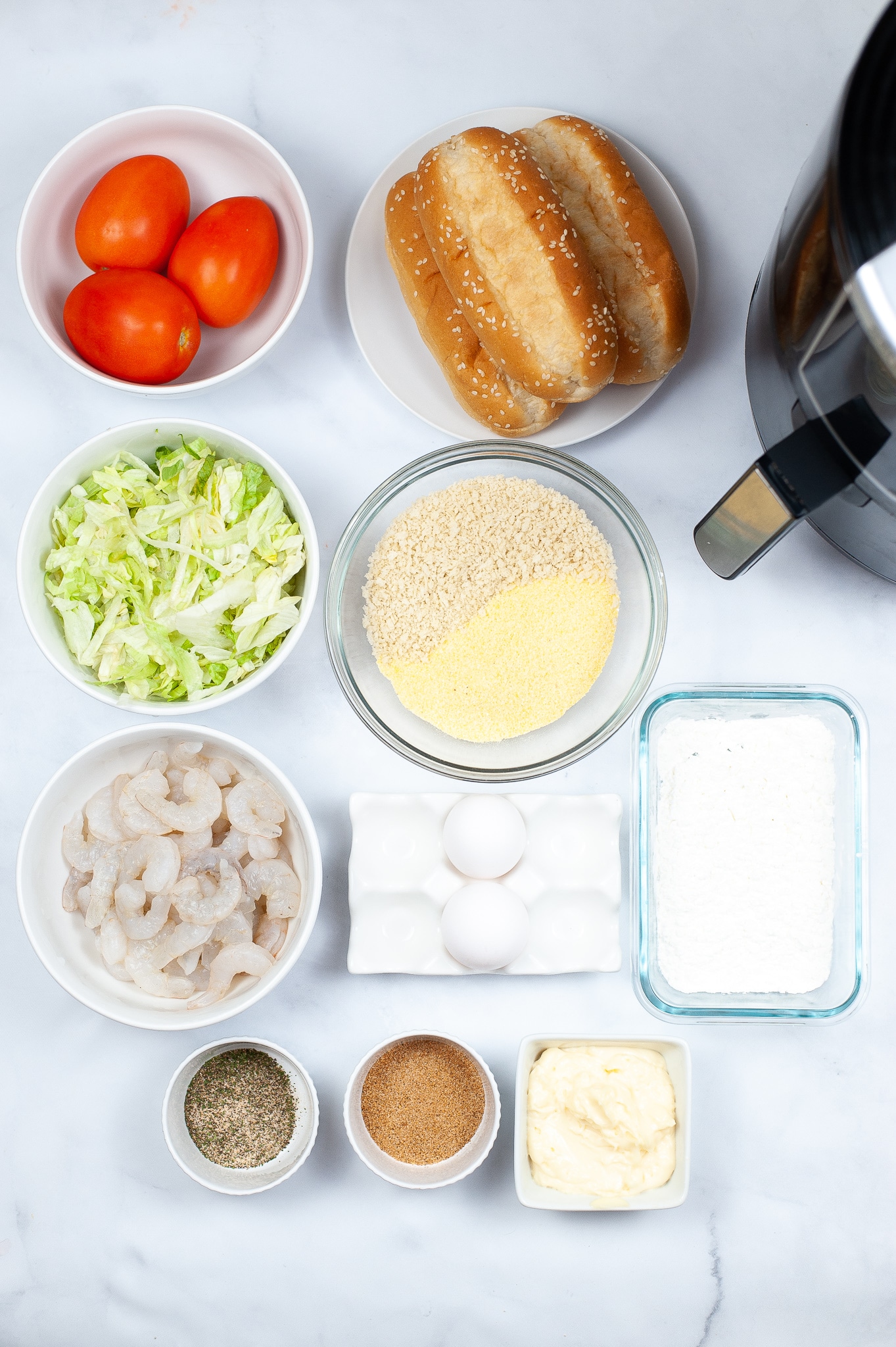 Ingredients for air fryer po boys in separate dishes, laid out on a countertop