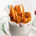 a silver cup holding carrot matchstick fries