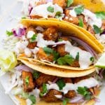 corn tortilla tacos stuffed with air fryer fish, garlic lime crema, cabbage and cilantro.