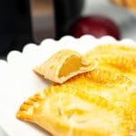 closeup view of air fryer apple hand pies on a white cake pedestal