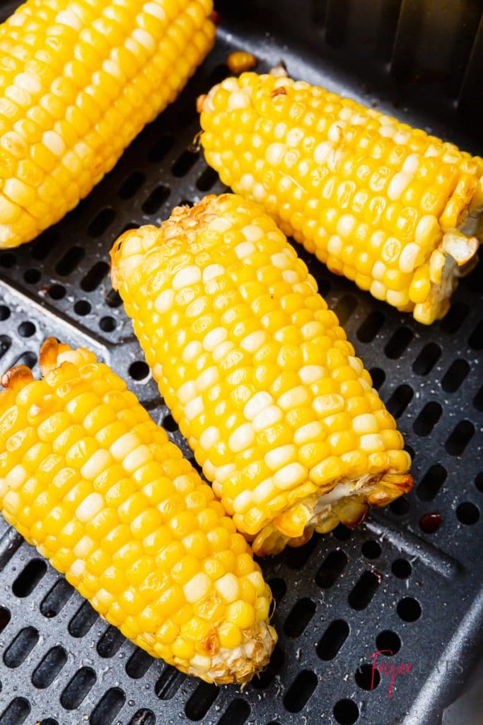 yellow half ears of corn in black air fryer basket