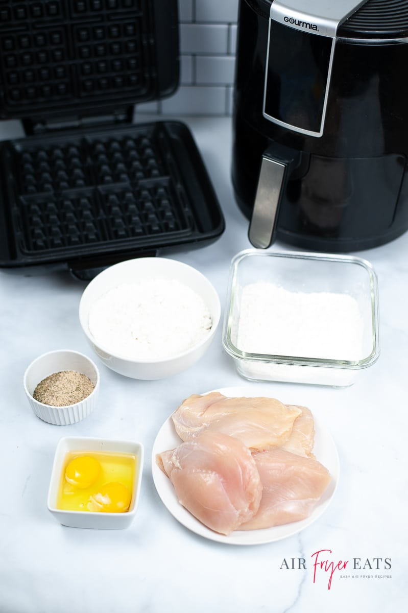 an air fryer and a waffle iron next to the 5 ingredients needed to make air fryer chicken and waffles.
